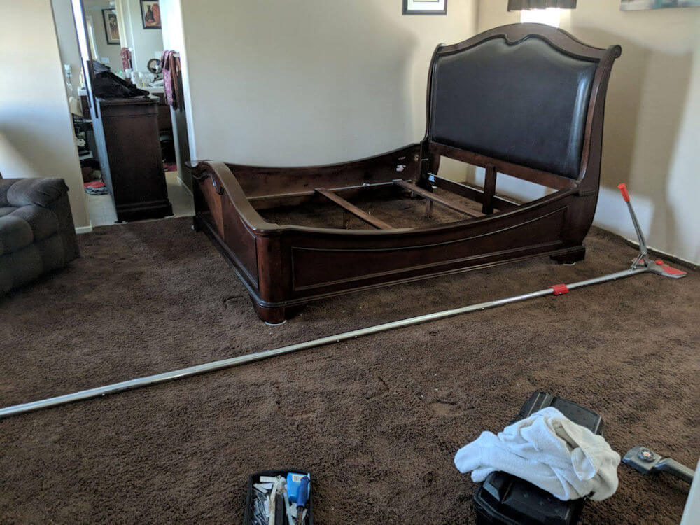 Restretching carpet in room with furniture